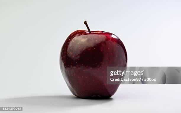 close-up of wet apple against white background - red delicious stockfoto's en -beelden