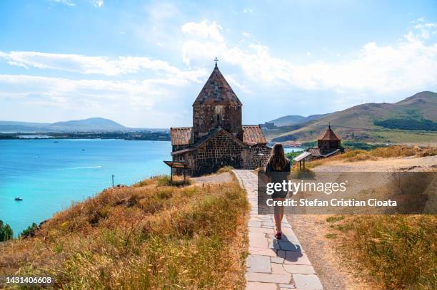 girl walking to sevanavank monastery on the shore of lake sevan, armenia - sevanavank monastery stock pictures, royalty-free photos & images