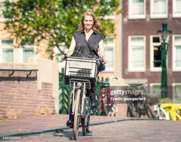 enjoying cycling in amsterdam - vintage rainwear stockfoto's en -beelden