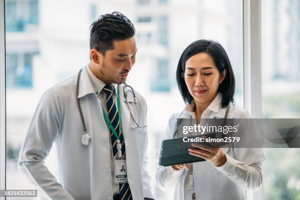 we should research more about this infection - two doctors talking stockfoto's en -beelden