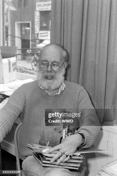 Writer Edward Gorey answers questions during an interview while signing his books.