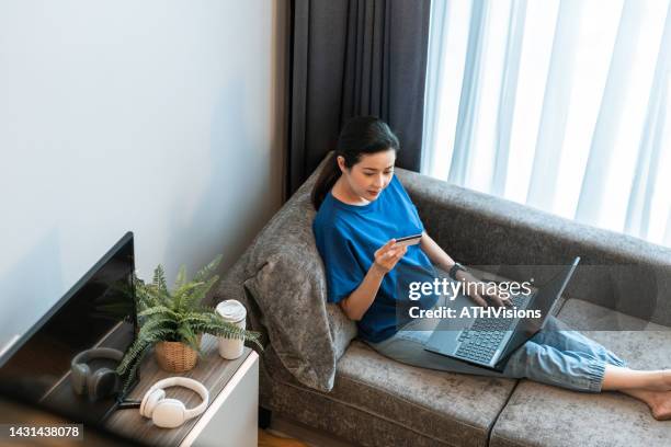 asian woman online purchase on laptop computer at home. - omnichannel retail stock pictures, royalty-free photos & images