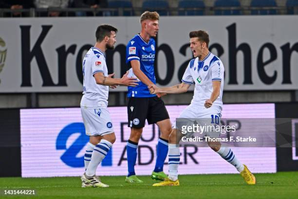 Jerome Gondorf and Marvin Wanitzek of Karlsruhe celebrate their teams second goal while Benjamin Kanuric of Bielefeld looks dejected during the...