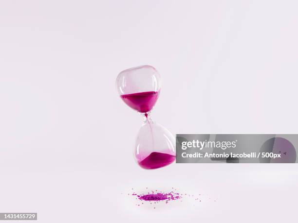 close-up of hourglass against white background - reloj de arena fotografías e imágenes de stock