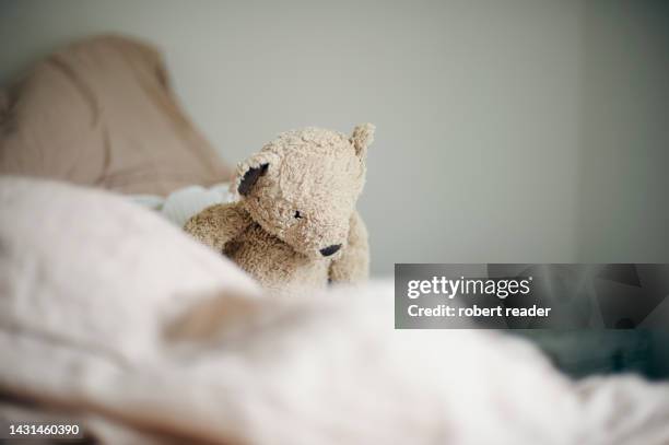 teddy bear on bed - teddy bear stock pictures, royalty-free photos & images