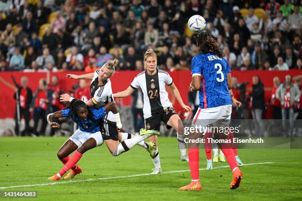 Alexandra Popp of Germany scores their team's first goal while challenged by Aissatou Tounkara of France during the international friendly match...