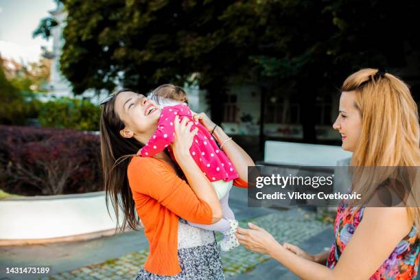 female friends meeting up on a sunny day in city park - aunyy stock pictures, royalty-free photos & images