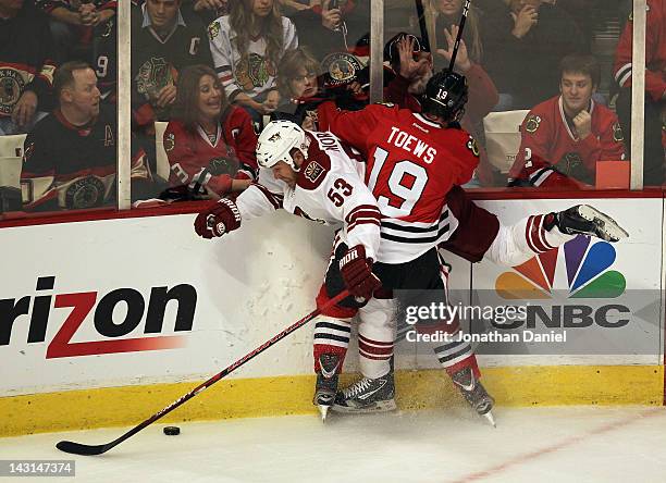 Jonathan Toews of the Chicago Blackhawks pins Derek Morris of the Phoenix Coyotes to the boards as they battle for the puck in Game Four of the...