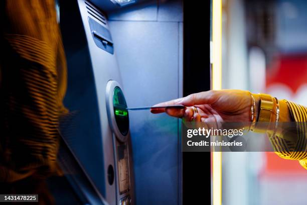 close up photo of woman hands using atm machine - geldautomaat stockfoto's en -beelden