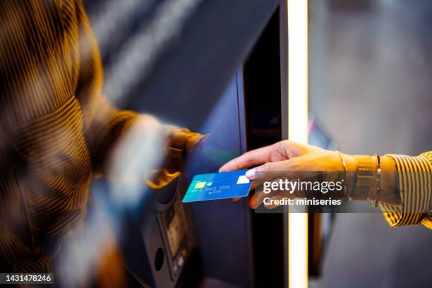 close up photo of woman hands using atm machine - inserting stock pictures, royalty-free photos & images