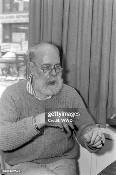 Writer Edward Gorey answers questions during an interview while signing his books.