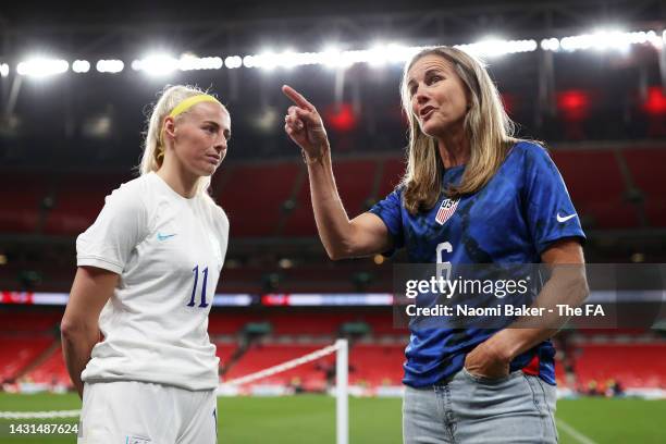 Chloe Kelly of England and Former United States player Brandi Chastain talk following the Women's International Friendly match between England and...