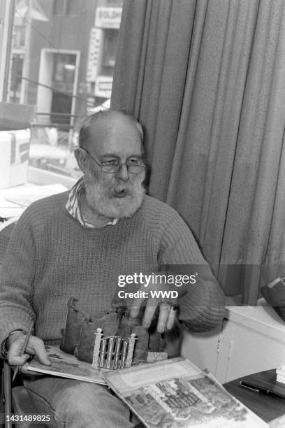 Writer Edward Gorey answers questions during an interview while signing his books.