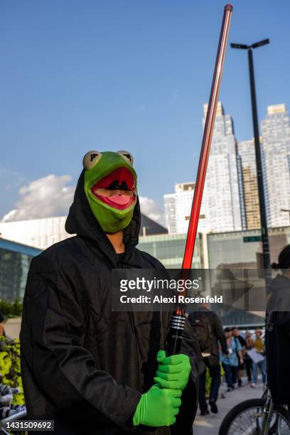 Person dressed as Kermit the Frog poses with a lightsaber outside Comic Con on October 07, 2022 in New York City. The four-day event, which began...