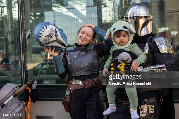 Family dressed as Star Wars' Mandalorian and Baby Yoda pose outside comic con on October 07, 2022 in New York City. The four-day event, which began...