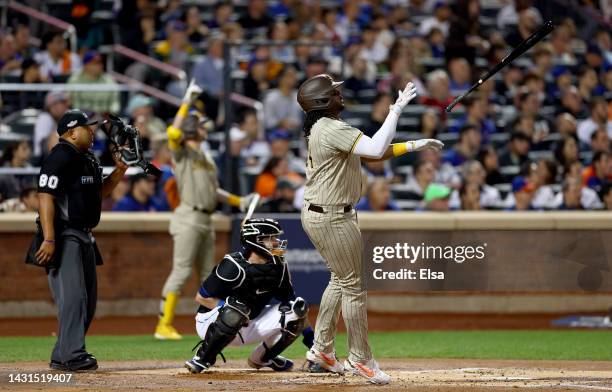 Josh Bell of the San Diego Padres hits a two run home run in the first inning as Tomas Nido of the New York Mets defends during game one of the NL...