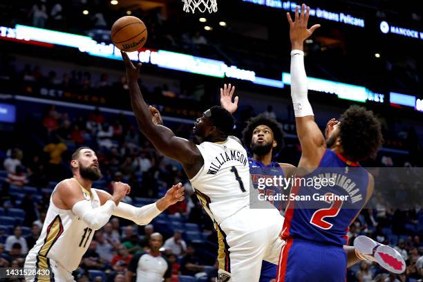 Zion Williamson of the New Orleans Pelicans shoots past Marvin Bagley III of the Detroit Pistons and Cade Cunningham of the Detroit Pistons during...