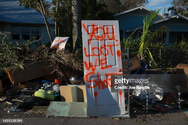 Spray painted door reads 'you loot. We shoot.' on October 07, 2022 in Fort Myers, Florida. Hurricane Ian brought high winds, storm surges, and rain...