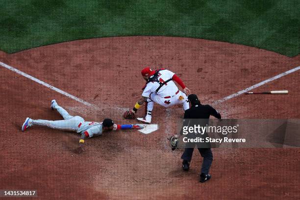 Edmundo Sosa of the Philadelphia Phillies beats a tag at home by Yadier Molina of the St. Louis Cardinals during the ninth inning of Game One of the...