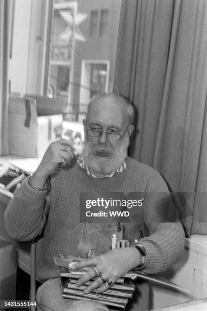 Writer Edward Gorey answers questions during an interview while signing his books.