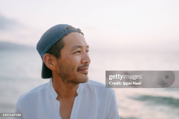 man contemplating on beach at sunset - profile picture man stock-fotos und bilder