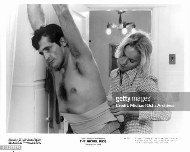 Jason Miller is treated by Linda Haynes after having fight with his brother in a scene from the film 'The Nickel Ride', 1974.