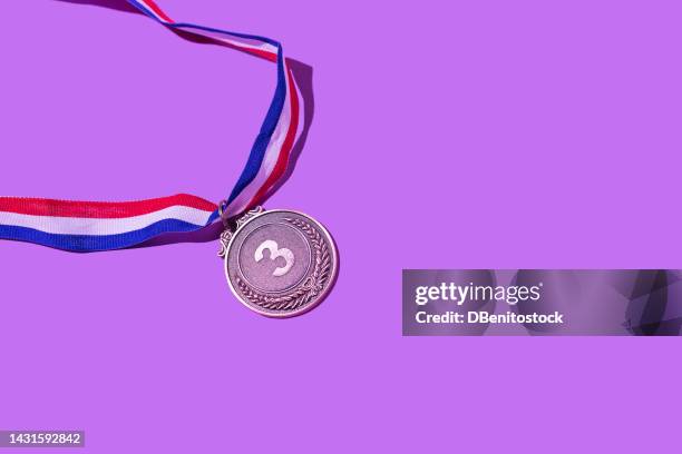 bronze medal with the number 3, as the third classified, on a purple background. concept of winner, medals, honor, women's day, winning woman, working woman and sports competition. - awards day 3 stock pictures, royalty-free photos & images