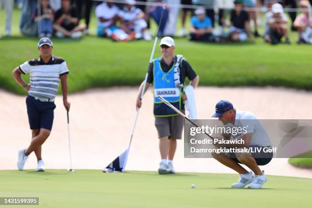 Team Captain Bryson DeChambeau of Crushers GC lines up a putt on the 18th green as Hideto Tanihara of Torque GC looks on during Day Two of the LIV...