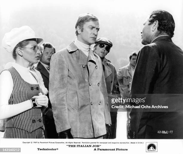 Margaret Blye, Benny Hill, Michael Caine, and Michael Standing looking at unidentified man talking in a scene from the film 'The Italian Job', 1969.