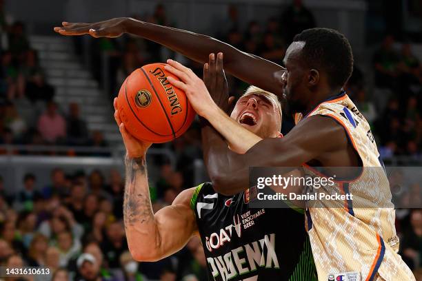 Mitchell Creek of the Phoenix is fouled by Majok Deng of the Taipans during the round two NBL match between South East Melbourne Phoenix and Cairns...