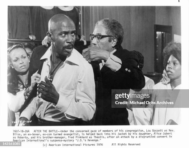 Alice Jubert and Fred Pinkhard help Lou Gossett Jr into his jacket in a scene from the film 'J.D.'s Revenge', 1976.