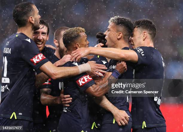 Nicholas D'Agostino of Victory celebrates scoring a goal with Ben Folami and Nani of Victory during the round one A-League Men's match between Sydney...