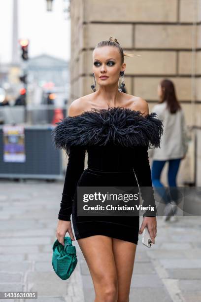 Alessia Merzlova wears black dress with faux fur element, green bag, heels outside Alessandra Rich during Paris Fashion Week - Womenswear...