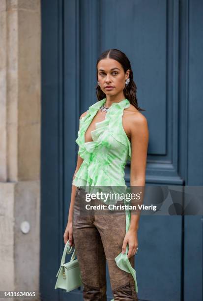 Sarah Lysander wears green ruffled top, brown black jeans, mint green bag earrings outside Alessandra Rich during Paris Fashion Week - Womenswear...