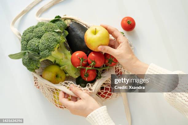 verdure fresche nel sacchetto eco riutilizzabile al bancone della cucina - mature adult foto e immagini stock