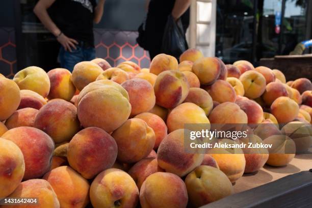 ripe peaches. the concept of growing organic products, selling agricultural products. vegetable food. food background of fruits. retail at a farmer's market, sales at a store or hypermarket. harvest season. from the farm to the table. - georgia peach fotografías e imágenes de stock