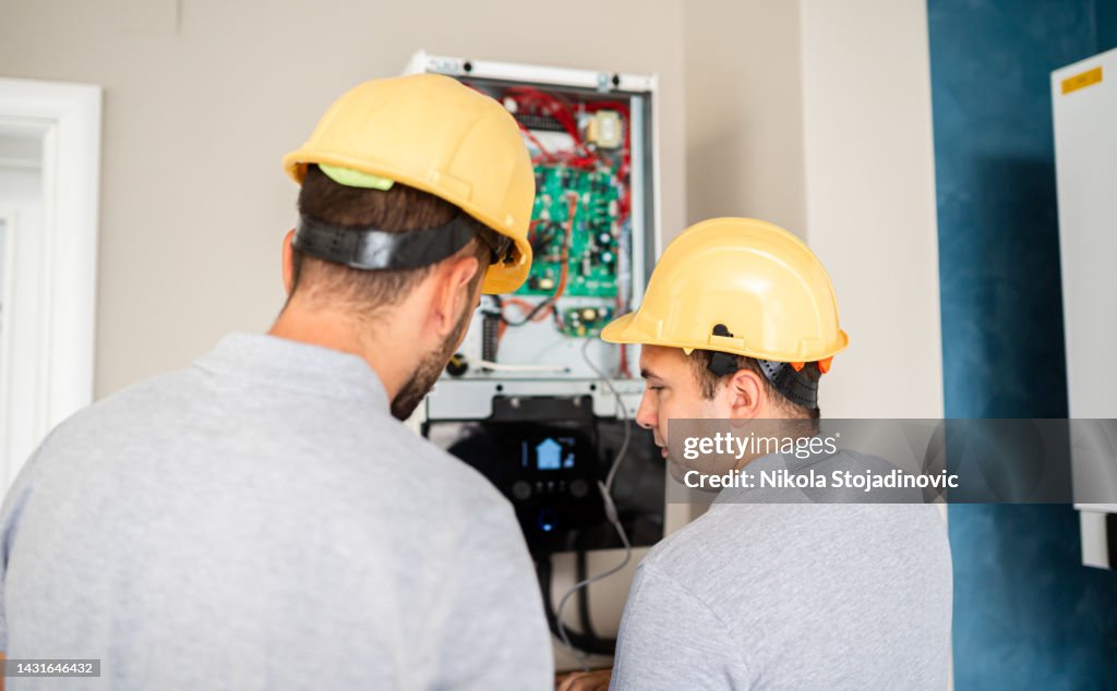 Trabalhadores verificam o ar condicionado