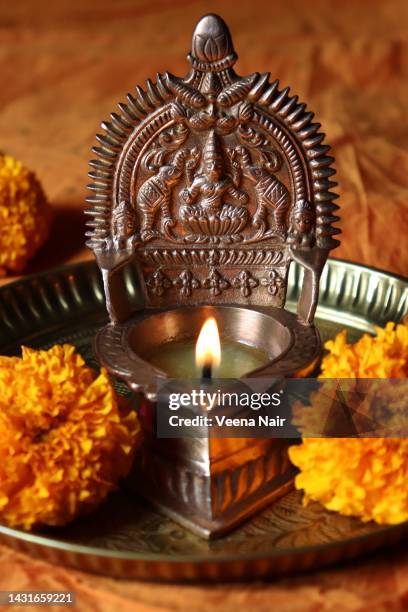 lit oil brass goddess lakshmi /gajalakshmi vilakku in a copper plate with marigold flowers/diwali/deepavali festival - diya oil lamp fotografías e imágenes de stock