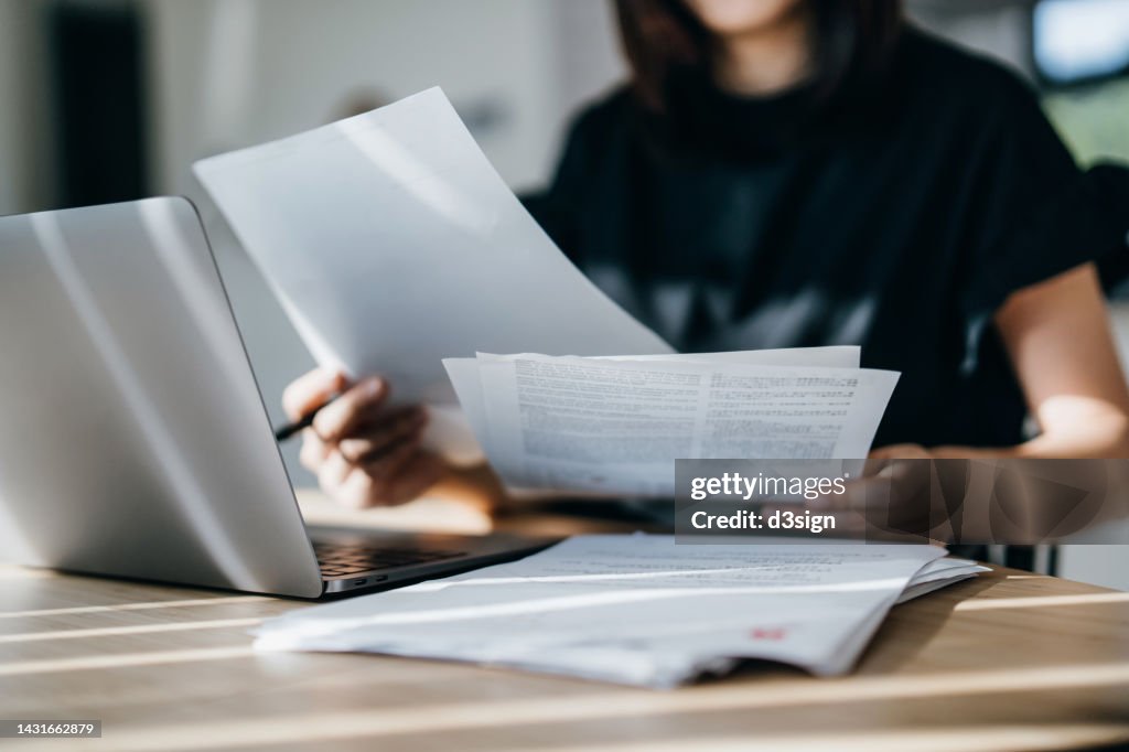 Cropped shot of young Asian woman handling personal banking and finance with laptop at home. Planning budget and calculating expenses. Managing taxes and financial bills. Wealth management. Digital banking habits. Smart banking with technology