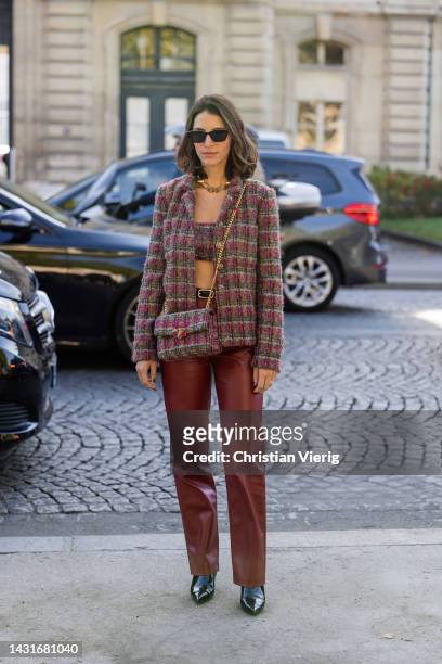 Guest wears blazer, cropped top, bag, red leather pants outside Chanel during Paris Fashion Week - Womenswear Spring/Summer 2023 : Day Nine on...