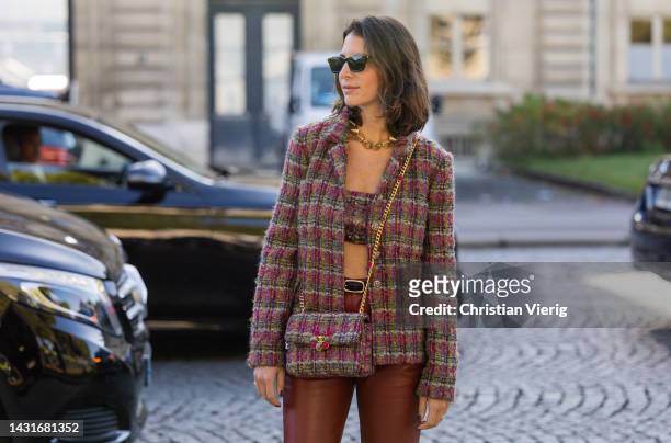 Guest wears blazer, cropped top, bag, red leather pants &outside Chanel during Paris Fashion Week - Womenswear Spring/Summer 2023 : Day Nine on...