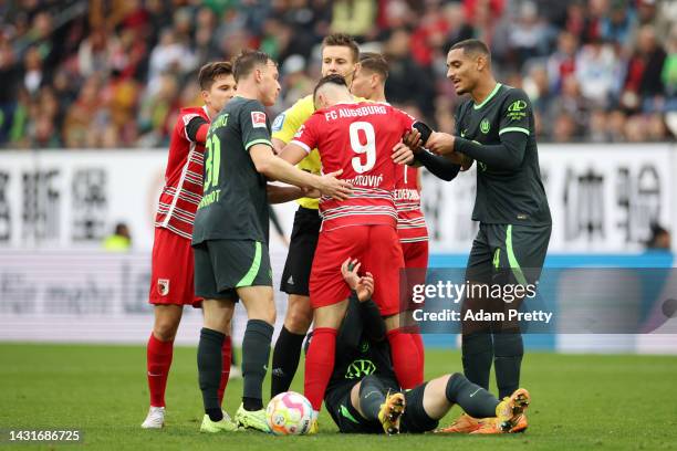 Ermedin Demirovic of Augsburg clashes with Maximilian Arnold of VfL Wolfsburg during the Bundesliga match between FC Augsburg and VfL Wolfsburg at...