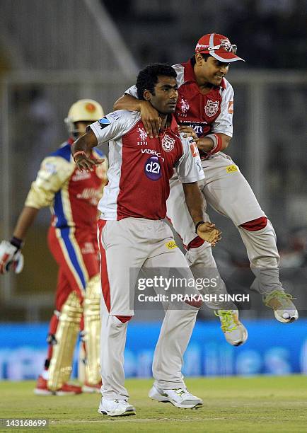 Kings XI Punjab bowler Parvinder Awana celebrates taking the wicket of Royal Challengers Bangalore batsman Mayank Agarwal with teammates during the...