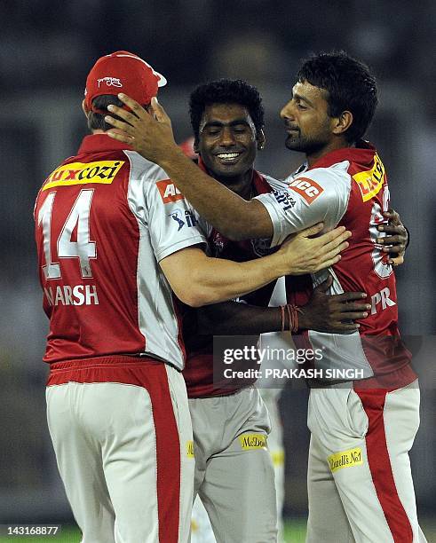 Kings XI Punjab bowler Parvinder Awana celebrates taking the wicket of Royal Challengers Bangalore batsman Virat Kohli with teammates during the IPL...