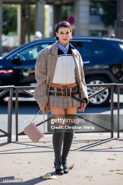 Alyssa Coscarelli wears oversized checkered brown blazer, mini skirt with brown belt, grey knee high socks, rose bag, zipper jumper outside Miu Miu...