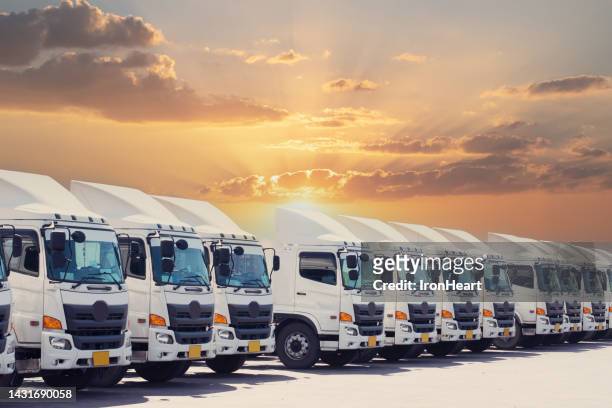 truck fleet with sunset. - convoy stockfoto's en -beelden