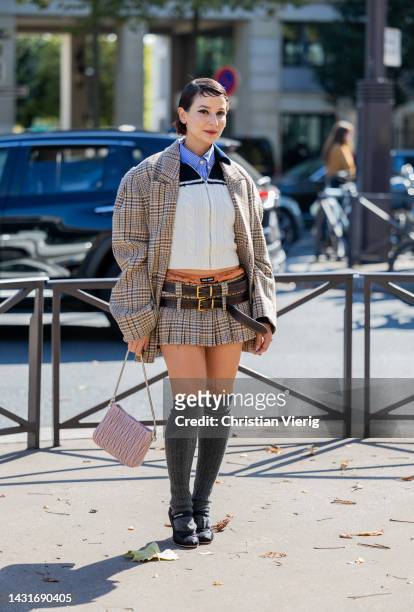 Alyssa Coscarelli wears oversized checkered brown blazer, mini skirt with brown belt, grey knee high socks, rose bag, zipper jumper outside Miu Miu...
