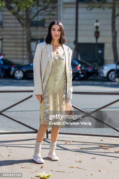 Brittany Xavier wears yellow laced see trough dress, latte blazer, rose bag outside Miu Miu during Paris Fashion Week - Womenswear Spring/Summer 2023...