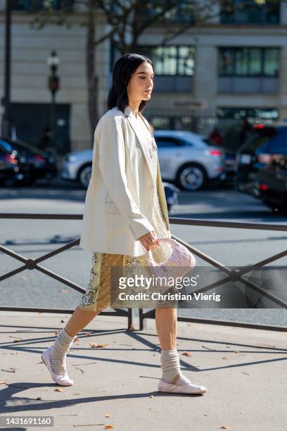 Brittany Xavier wears yellow laced see trough dress, latte blazer, rose bag outside Miu Miu during Paris Fashion Week - Womenswear Spring/Summer 2023...