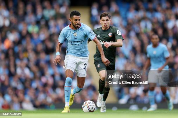 Riyad Mahrez of Manchester City runs with the ball from Romain Perraud of Southampton during the Premier League match between Manchester City and...
